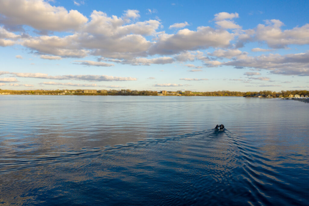 an aerial photo of a lake with a boat in the middle