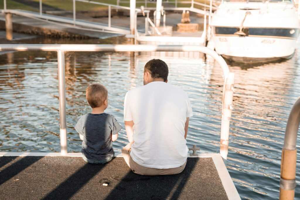 a man and a bot sitting on dock