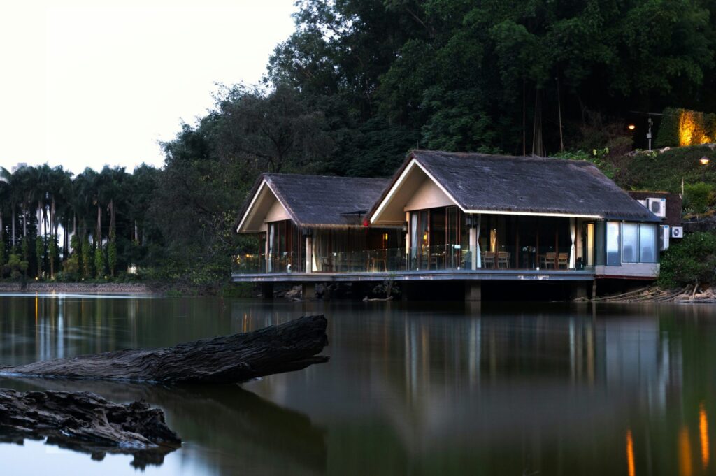 two modern houses on stilts over a lake
