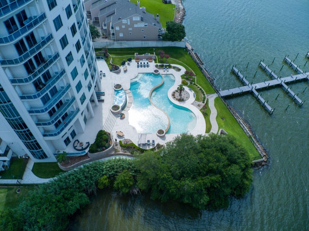 an aerial view of a pool and dock at a water front condo building