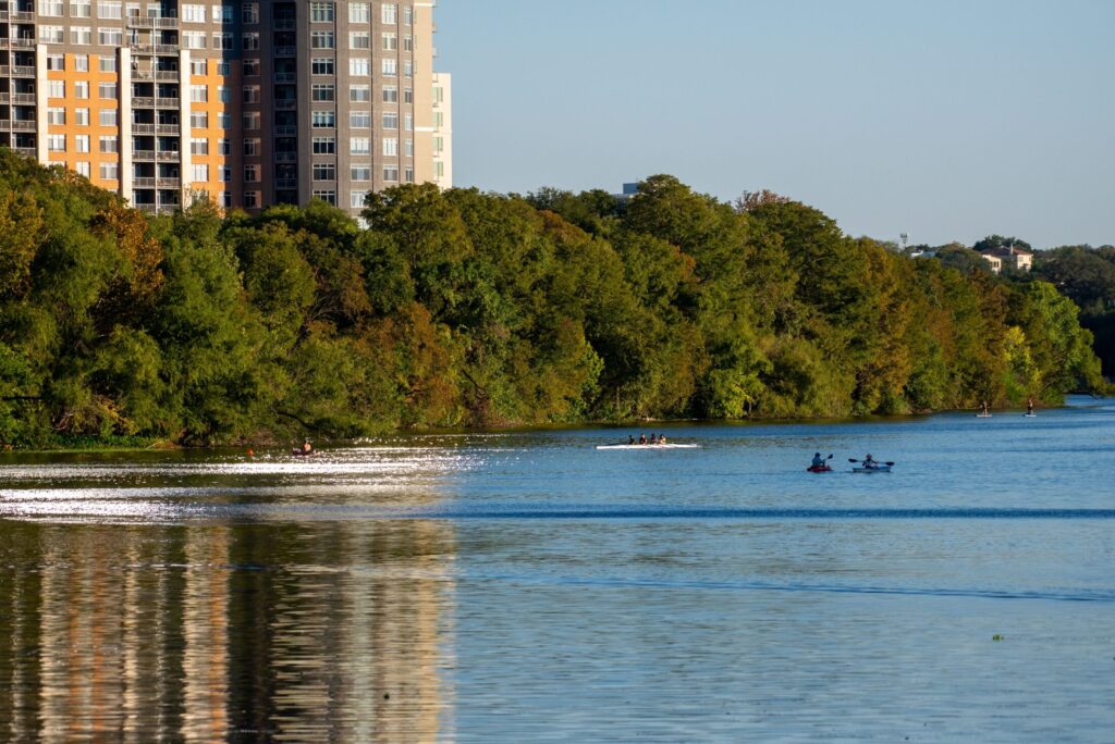 people kayaking on a river in city